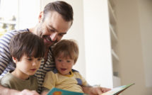 dad and boys reading a book