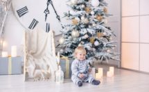 baby boy in pajamas with stars celebrates Christmas