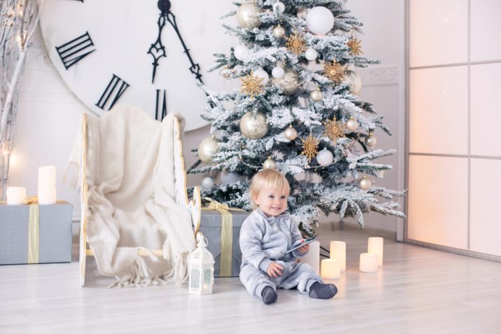 baby boy in pajamas with stars celebrates Christmas