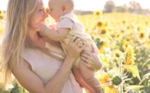 mom and baby smiling in a sunflower field