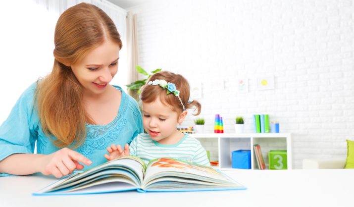 mother and child reading a book together at home