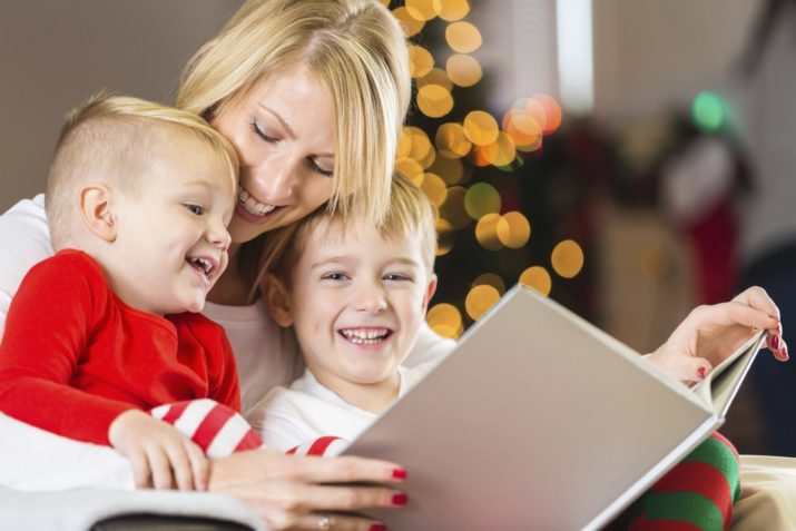 Mother reading Christmas story to happy little boys