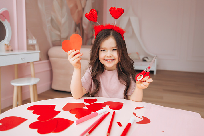 A girl crafting paper hearts 