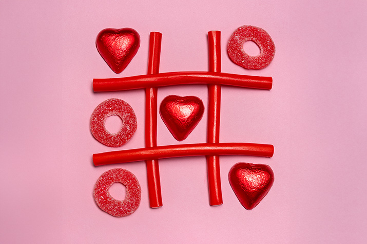 A tic-tac-toe game board made from candy hearts and licorice
